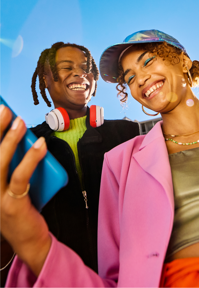 Boy and girl smiling at her smartphone