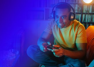 Man excitedly playing a video game on the console while wearing headphones