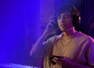 man with headphones holding a gaming controller