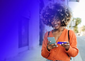 woman walking outside and using her prepaid card to pay