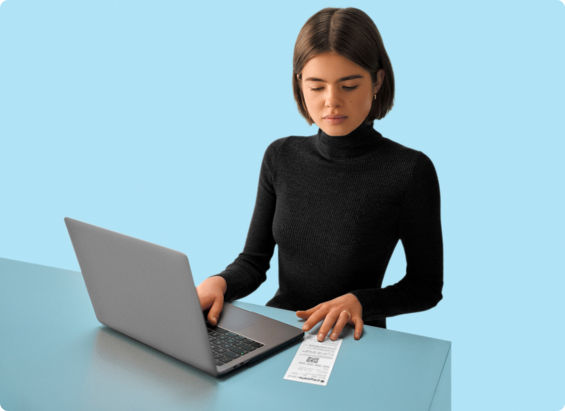 Woman with laptop holding a PaysafeCard codes