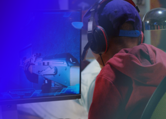 a boy wearing headphones playing a video game at his gaming computer